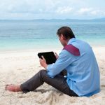 man on beach with tablet