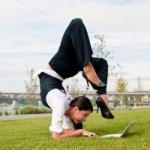 woman doing yoga while on laptop