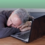 man sleeping by laptop