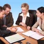 4 employees sitting at table during meeting